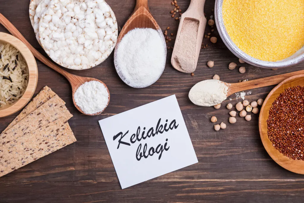 Gluteenittomia viljoja ja leipiä puupöydällä, keskellä lappu jossa lukee Keliakia blogi.